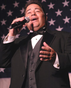 Tenor Daniel Rodriguez sings "God Bless America" during the USO Metro awards in Arlington, Va., March 25, 2008. DoD photo by Air Force Tech. Sgt. Adam M. Stump. (Released)